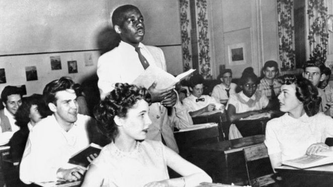 Чернокожий ученик стоит в средней школе в школе в Вашингтоне в 1954 году после постановления