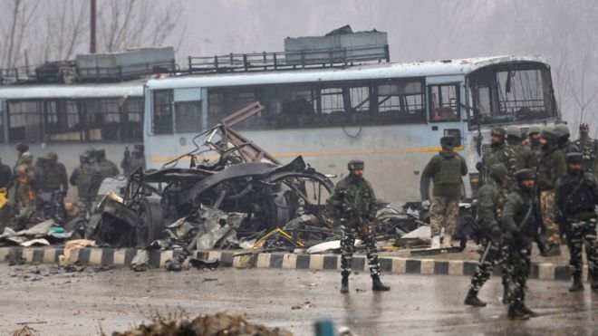 Security forces near the damaged vehicles at Lethpora on the Jammu-Srinagar highway, on February 14, 2019 in Srinagar, India