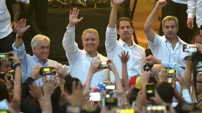 Президент Чили Себастьян Пинера, президент Колумбии Иван Дуке, лидер оппозиции Венесуэлы Хуан Гуайдо и президент Парагвая Марио Абдо Бенитес машут на концерте «Venezuela Aid Live».