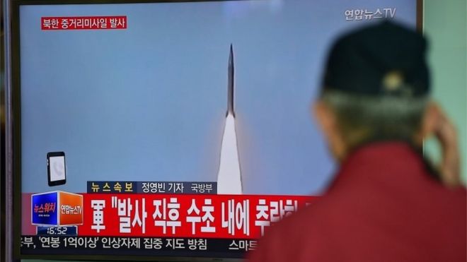 A man watches a TV news showing file footage of a North Korean missile launch at a railway station in Seoul (28 April 2016)