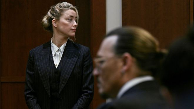 Amber Heard en el fondo y Johnny Depp fuera de foco durante su juicio por difamación, 17 de mayo de 2022