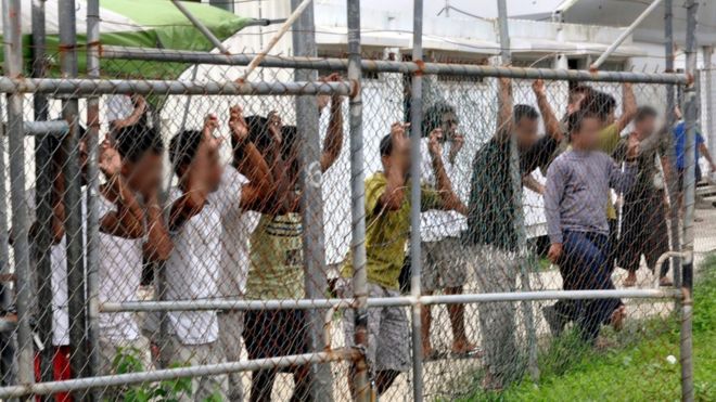 На снимке, датированном 21 марта 2014 года, изображены лица, ищущие убежища, за забором в центре содержания под стражей на острове Манус в Папуа-Новой Гвинее