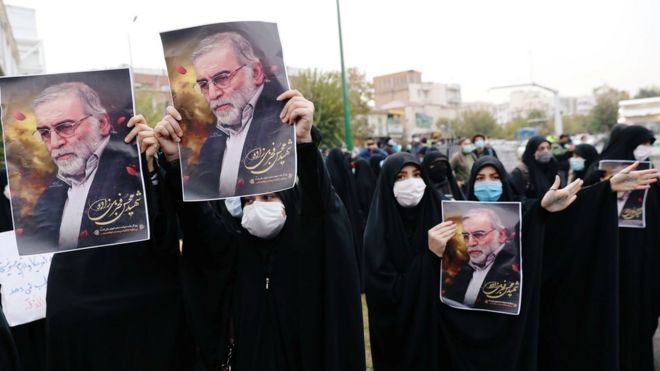 -Mujeres cubiertas con mascarillas sostienen carteles con la imagen de Mohsen Fakhrizadeh en Teherán, Irán