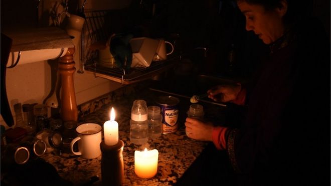 Жінка запалює свічки після того, як світло зникло в її будинку в столиці Уругваю Монтевідео