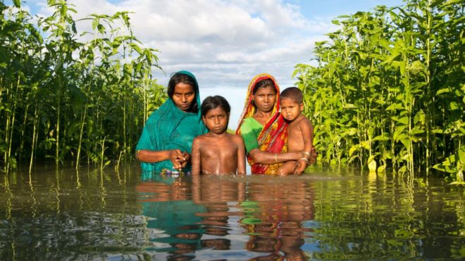 Famille dans les eaux d'inondation au Bangladesh