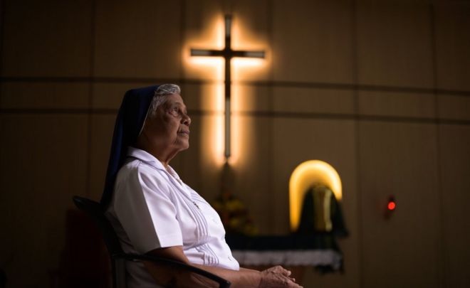 Gerard Fernandez, 81, é retratada de perfil dentro de convento, onde se vê um crucifixo na parede