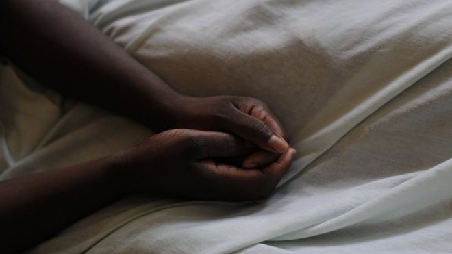 A woman who was raped two years ago rests her hands on her bed sheets at a hospital in Goma on 24 November 2008