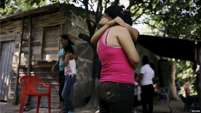 Женщины обнимают друг друга, когда оплакивают своих кузенов, Олокуилта, Сальвадор (15 июля 2015 года)