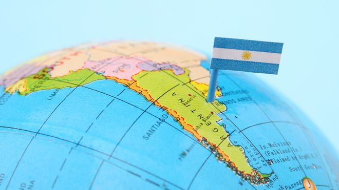 Globo terráqueo con un banderín de Argentina sobre la imagen del país