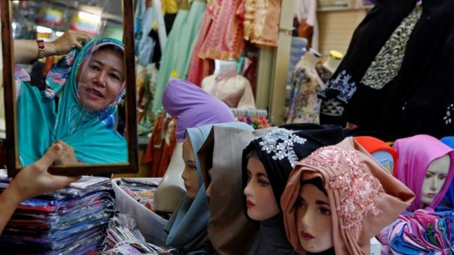 Женщина покупает платки перед Ид аль-Фитр в Джакарте, Индонезия