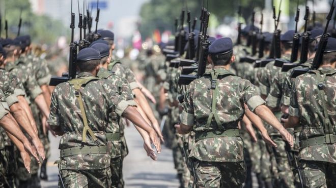 Militares brasileiros marcham com armas