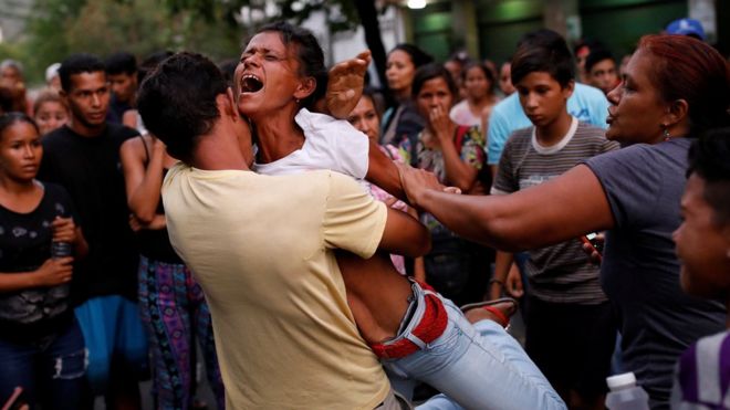 Relatives of inmates held at the General Command of the Carabobo Police react as they wait outside the prison, where a fire occurred in the cells area, according to local media, in Valencia, Venezuela, 28 March