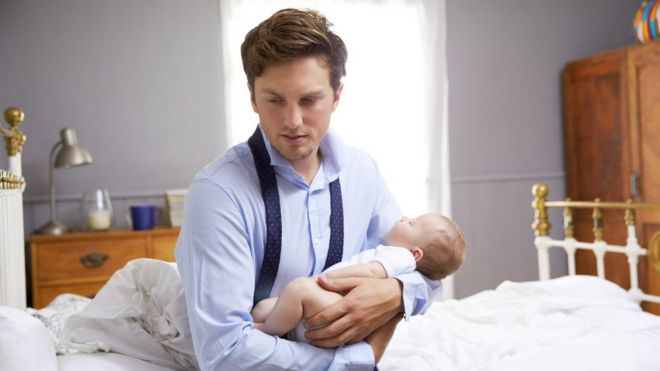 Hombre cargando a un bebé