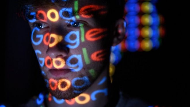 Varios logos de Google reflejados sobre la cara de un hombre