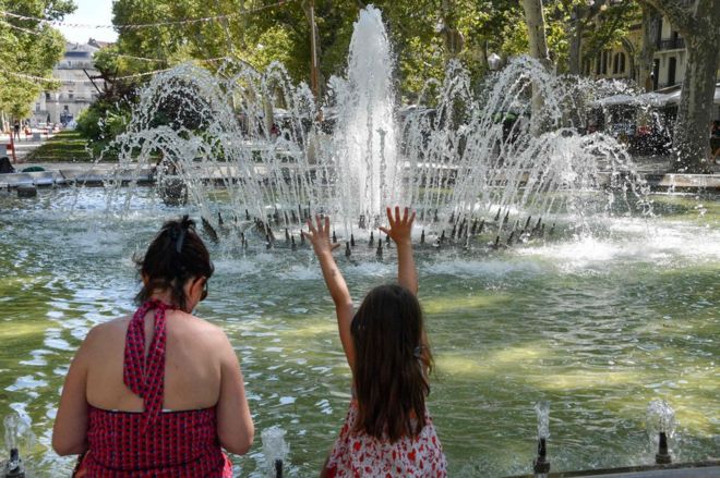 Женщина и ребенок остывают у фонтана в Монпелье