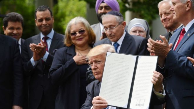 Президент США Дональд Трамп подписывает распоряжение в Розовом саду Белого дома.