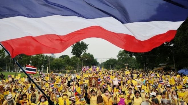 Royalists wearing yellow shirts of which one is waving a Thailand"s flag, march during an event to support the monarchy in Bangkok, Thailand, October 27,2020.