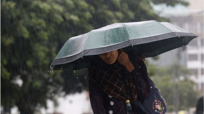 ঘূর্ণিঝড় সিত্রাংয়ের কারণে নিরাপদ আশ্রয়ে যাওয়ার চেষ্টা করছেন একজন নারী