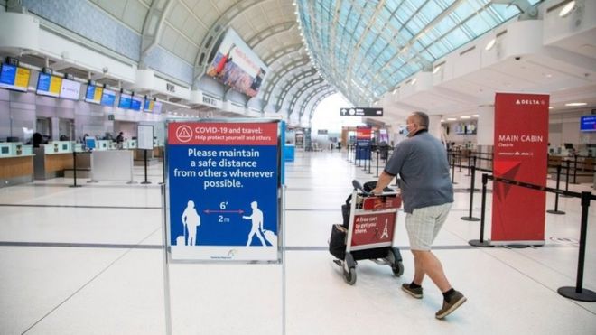 A man pushes a cart at an airport in Toronto