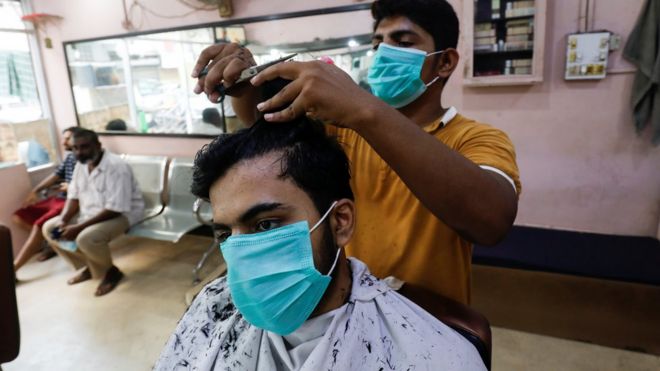Мужчина носит защитную маску во время стрижки в парикмахерской после того, как Пакистан снял ограничения, поскольку вспышка коронавирусной болезни (Covid-19) продолжается, в Карачи, Пакистан, 10 августа 2020 г.
