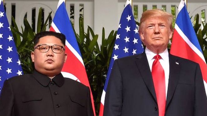 US President Donald Trump (R) poses with North Korea's leader Kim Jong Un (L) at the start of their historic US-North Korea summit