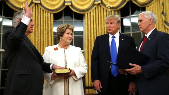 Госсекретарь США Рекс Тиллерсон приведен к присяге вице-президентом США Майком Пенсом, поскольку его жена Ренда Сент-Клер держит Библию в сопровождении президента Дональда Трампа во время церемонии в Овальном кабинете