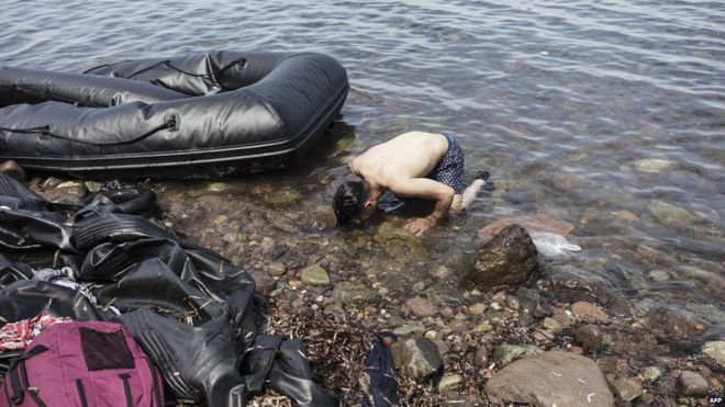 Сирийский мужчина целует землю, когда он входит в Европу