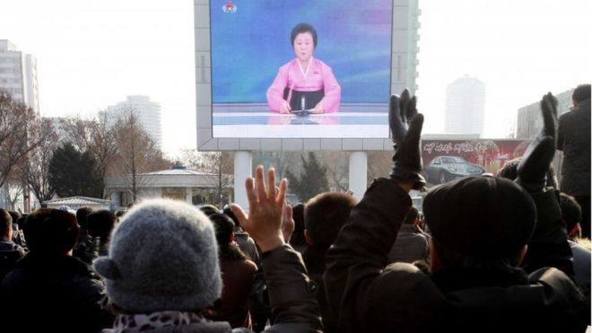 Северные корейцы смотрят трансляцию новостей на видеоэкране возле железнодорожного вокзала Пхеньяна в Пхеньяне, Северная Корея, в среду, 6 января 2016 года.