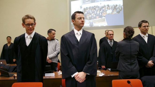 Адвокаты беседуют с Беате Жапе перед продолжением судебного процесса в зале суда в Мюнхене