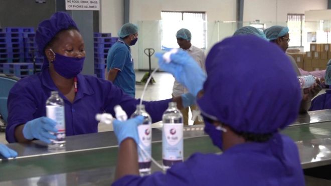 Рабочие производят дезинфицирующие средства для рук на ликеро-водочном заводе в Уганде