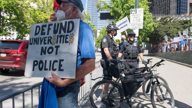 Протестующие собрались перед зданием мэрии Сиэтла, прежде чем было урезано финансирование полиции