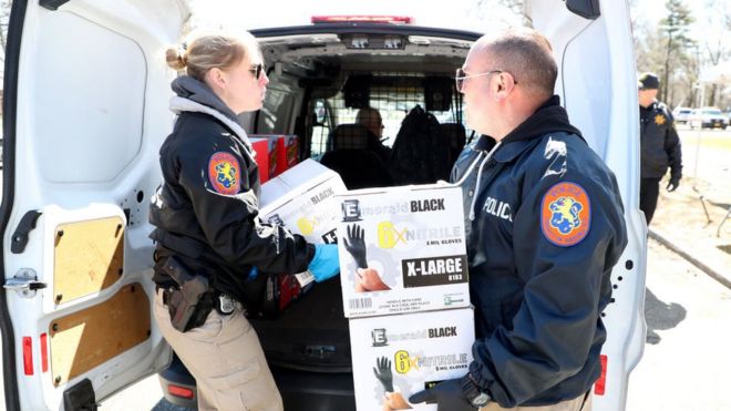 Policías cargando cajas de guantes en Nueva York