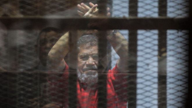 الرئيس المصري السابق محمد مرسي بالزي الاحمر في قفص الاتهام