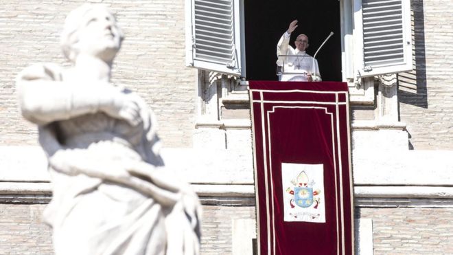 Папа Фрэнсис машет паломникам и туристам, собравшимся на площади Святого Петра в Ватикане 1 ноября 2015 года