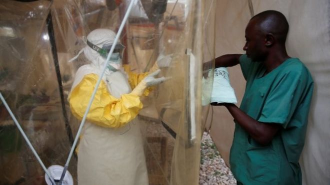 Медицинский работник в защитном снаряжении от лихорадки Эбола входит в центр лечения лихорадки Эбола в Демократической Республике Конго