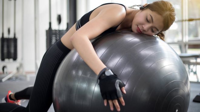 Mujer durmiendo mientras hace ejercicio