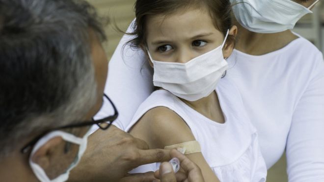 Niño siendo atendido por un doctor.