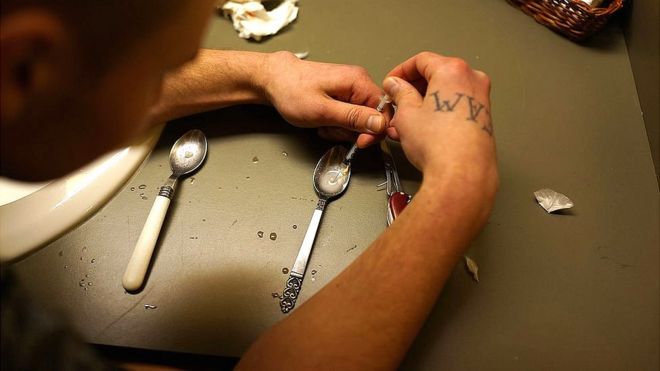 Un hombre prepara una dosis de heroína para inyectársela.