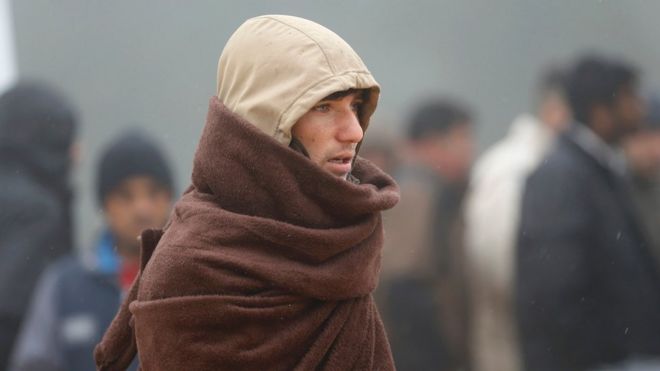 A migrant wraps-up against the cold weather, at a temporary registration centre in the village of Schwarzenborn, northeast of Frankfurt, Germany October 15, 2015.
