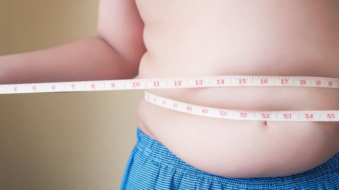Imagem mostra criança com fita métrica enrolada na cintura