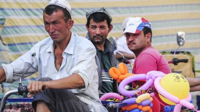 Uighur men on a vehicle in Xinjiang (file image