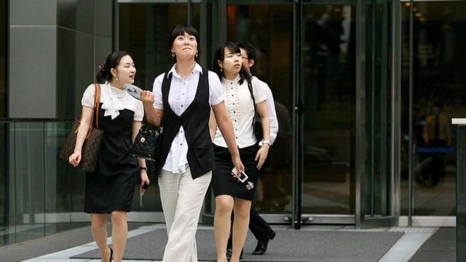 Деловые женщины покидают офисное здание в центре Сеула, Южная Корея