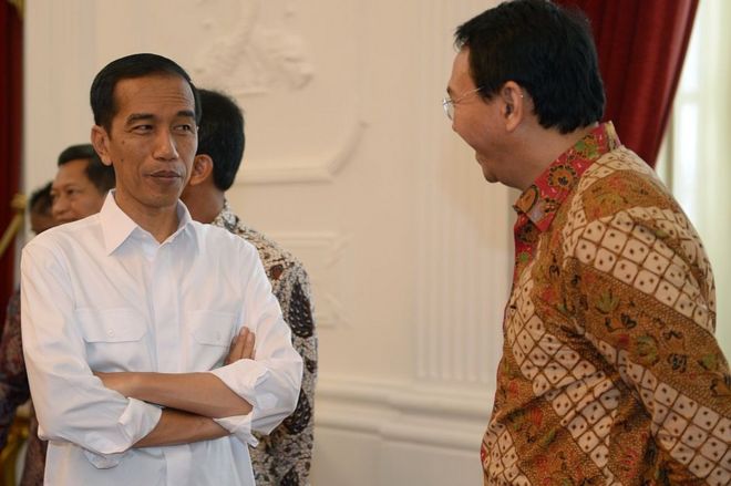 Президент Индонезии Джоко Видодо (слева) слушает исполняющего обязанности губернатора Джакарты Басуки Тяхаджа Пурнама по прозвищу Ахок (справа) в президентском дворце в Джакарте 22 октября 2014 года.