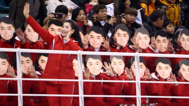 Болельщики Северной Кореи в масках во время хоккейного матча