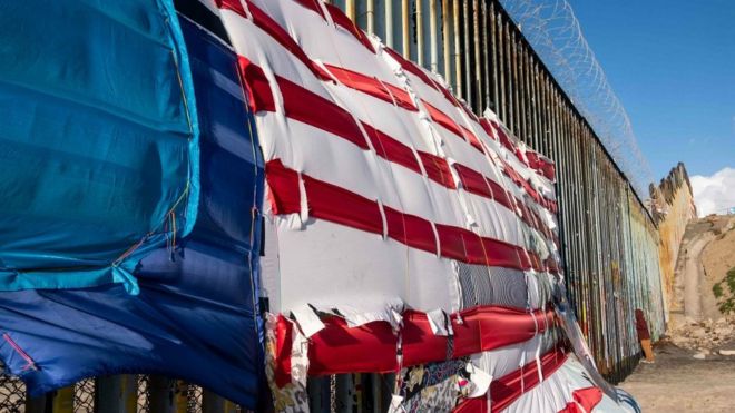 8 марта 2019 года на границе между США и Мексикой в ??Плайас-де-Тихуана, штат Нижняя Калифорния, Мексика, висит лоскутное одеяло с изображением американского флага.