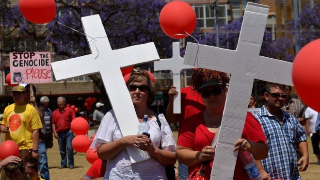 Белые южноафриканцы с воздушными шарами и крестами идут в знак протеста против насильственного убийства фермеров, которое они называют «геноцид и жестокая государственная политика в пользу черных» в Претории 10 октября 2013 г.
