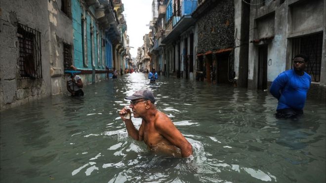 Hombre avanza por una calle inundada de La Habana tras el paso del huracán Irma.