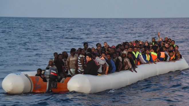 Мигранты на борту резиновой лодки от Ливии.Файл фотографии