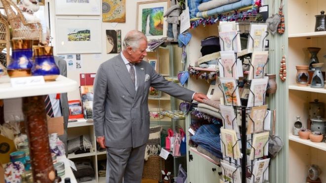 Принц Чарльз осматривает сувенирный магазин перед тем, как открыть витраж в Myddfai Community Hall около Llandovery, Carmarthenshire