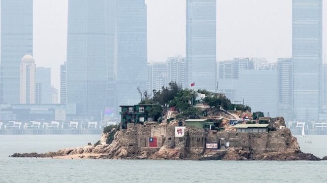 台湾金门离岛小岛——狮屿。岛上插有中华民国国旗，对面高楼大厦是福建厦门市（2018年4月20日资料照片）。